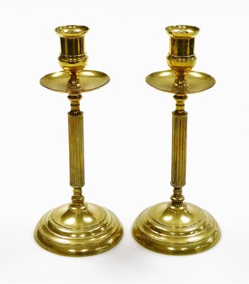Lot 124 - A pair of early 20thC brass candlesticks, each...