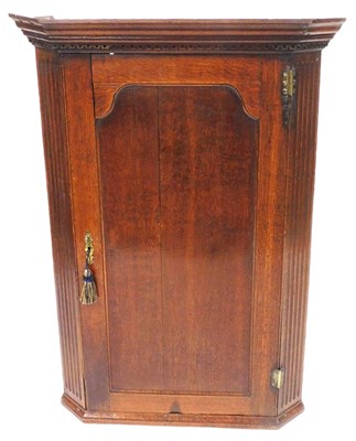 Lot 507 - A George III oak hanging corner cupboard, the...