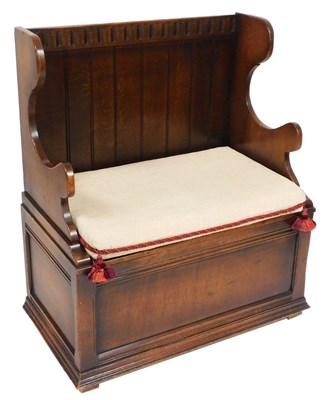 Lot 567 - An Old Charm style oak settle, with a panelled...