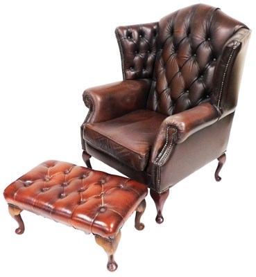 Lot 577 - A brown leather wing back armchair, with...