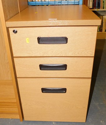 Lot 1143 - A light oak three drawer filing cabinet, 60cm...