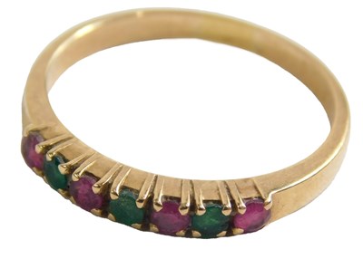 Lot 441 - A ruby and emerald half hoop dress ring, set...