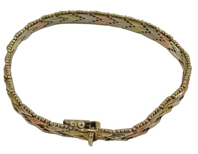 Lot 1028 - A three colour gold bracelet, in a textured...