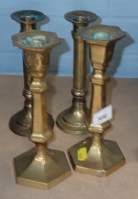 Lot 3050 - Two pairs of brass candlesticks, the largest...