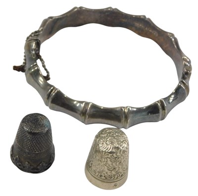 Lot 1038 - A silver bangle, in a bamboo design, on snap...