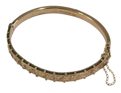Lot 1067 - A 9ct rose gold bangle, with engraved foliate...