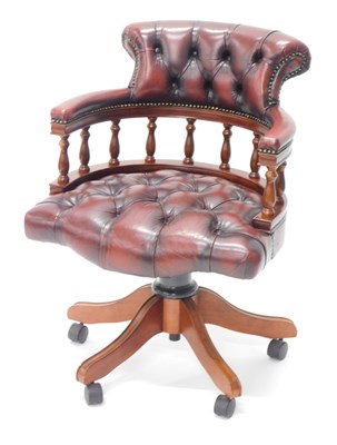 Lot 1544 - A mahogany and oxblood buttoned leather swivel...