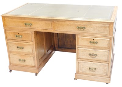 Lot 1547 - An early 20thC oak kneehole desk, the top with...
