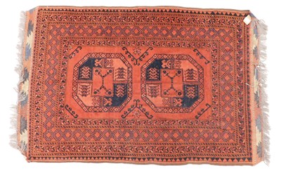 Lot 1580 - A Turkoman rug, with two medallions, on a red...