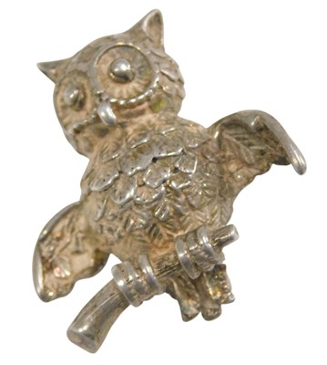 Lot 474 - A white metal brooch formed as an owl, perched...
