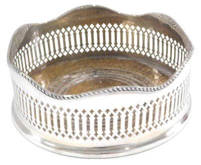 Lot 1130 - An Elizabeth II silver bottle coaster, with a...