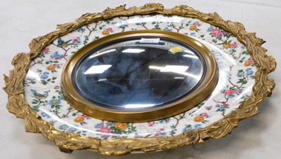 Lot 2021 - A gilt circular wall mirror, with porcelain...