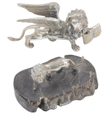 Lot 423 - A white metal griffin holding a book, 7cm wide,...