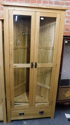 Lot 1001 - A light oak corner unit, of two glazed doors...