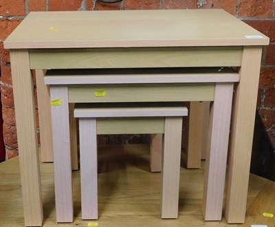 Lot 1003 - A light beech finish nest of three tables, the...