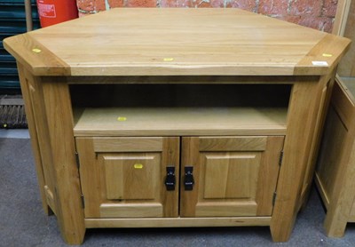 Lot 1004 - A light oak finished corner television cabinet,...