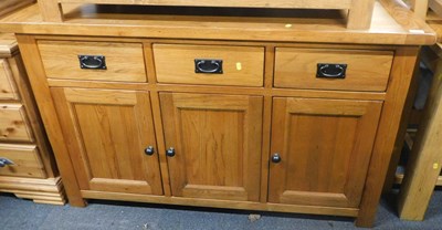 Lot 1007 - A light oak sideboard, of three drawers with...