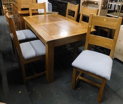Lot 1008 - A light oak extending dining table, and six...