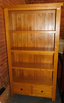 Lot 1010 - A light oak bookcase, of four shelves with two...