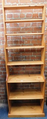 Lot 1025 - A pine waterfall bookcase, with eight shelves,...