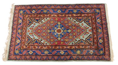 Lot 857 - A Persian rug, with a central lozenge, on a...