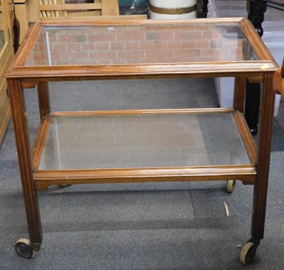 Lot 1068 - A two tier tea trolley, with glass shelves,...