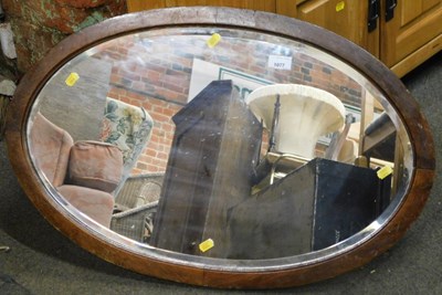Lot 1077 - An oval mahogany bevelled wall mirror.