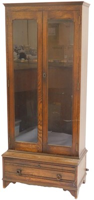 Lot 566 - An early 20thC oak gun cabinet, the top with a...