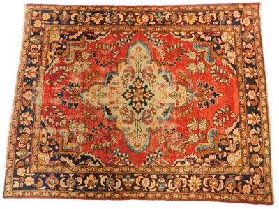 Lot 589 - A Persian red ground rug, decorated with a...