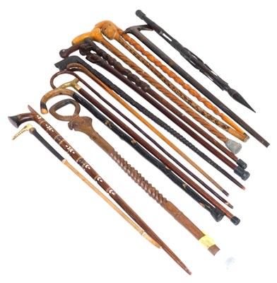Lot 70 - A group of African carved walking sticks, with...