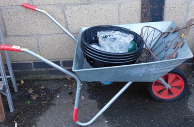 Lot 1020 - A metal wheel barrow, together with a black...