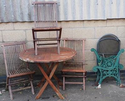 Lot 1016 - A wooden garden table, with circular top, on a...