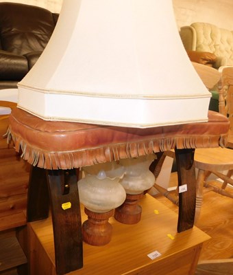 Lot 1122 - A camel stool with red leather seat, together...