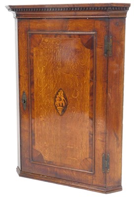 Lot 577 - A Georgian oak hanging corner cupboard, the...