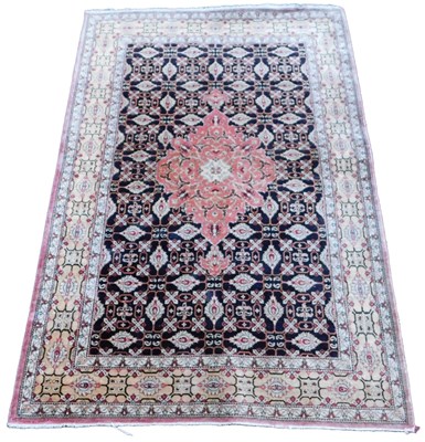 Lot 590 - A Tabriz black ground silk rug, central red...