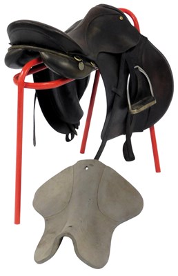 Lot 447 - A brown leather saddle, with stirrups, saddle...