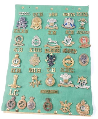 Lot 264 - A mounted collection of cap badges and...