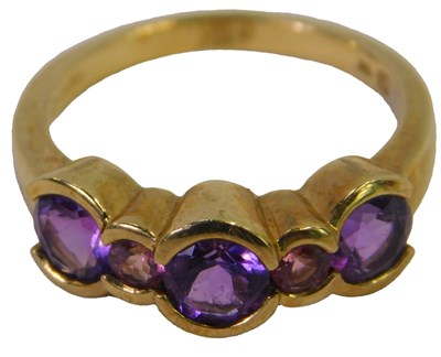 Lot 312 - A 9ct gold and amethyst three-stone ring,...