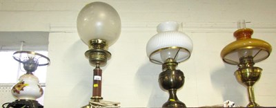 Lot 2128 - Four converted oil lamps, with chimneys and...