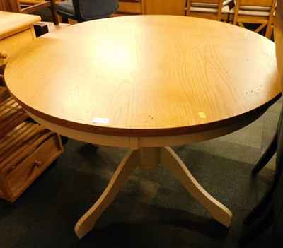 Lot 1021a - A circular oak dining table, raised on a...