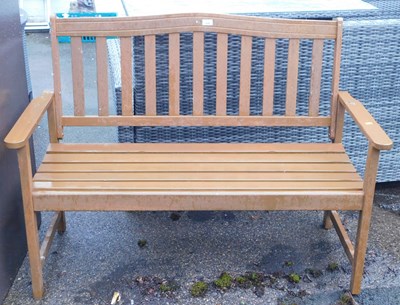 Lot 1082 - A brown painted garden seat, with slatted back...