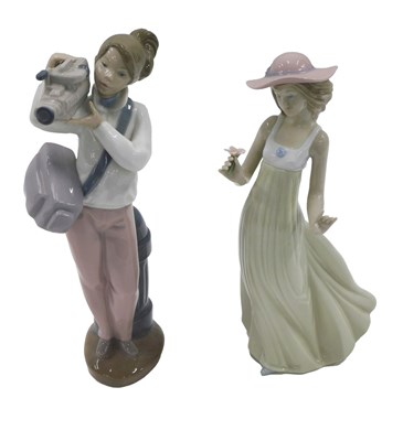 Lot 463 - Two Nao figures, one a lady with a video...