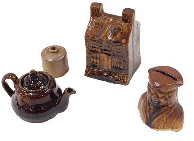 Lot 483 - A treacle glazed pottery money box, decorated...