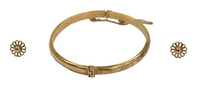 Lot 97 - A 9ct gold bangle, with engraved foliate...