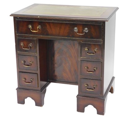 Lot 1098 - A mahogany kneehole desk, the top with a green...
