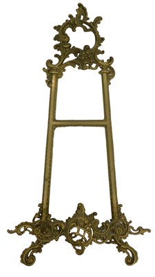 Lot 1031 - A rococo style brass picture stand, raised on...