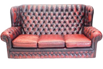 Lot 1255 - A red leather Chesterfield type wingback three...