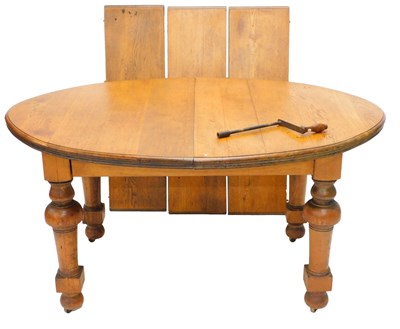 Lot 1240 - An oak extending dining table, with three...