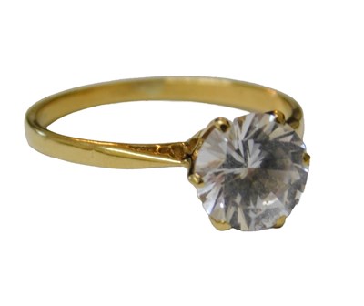 Lot 57 - A CZ solitaire ring, high claw set, yellow...
