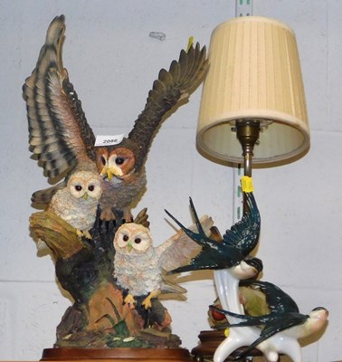 Lot 2086 - A resin owl figure group, on a wooden base,...